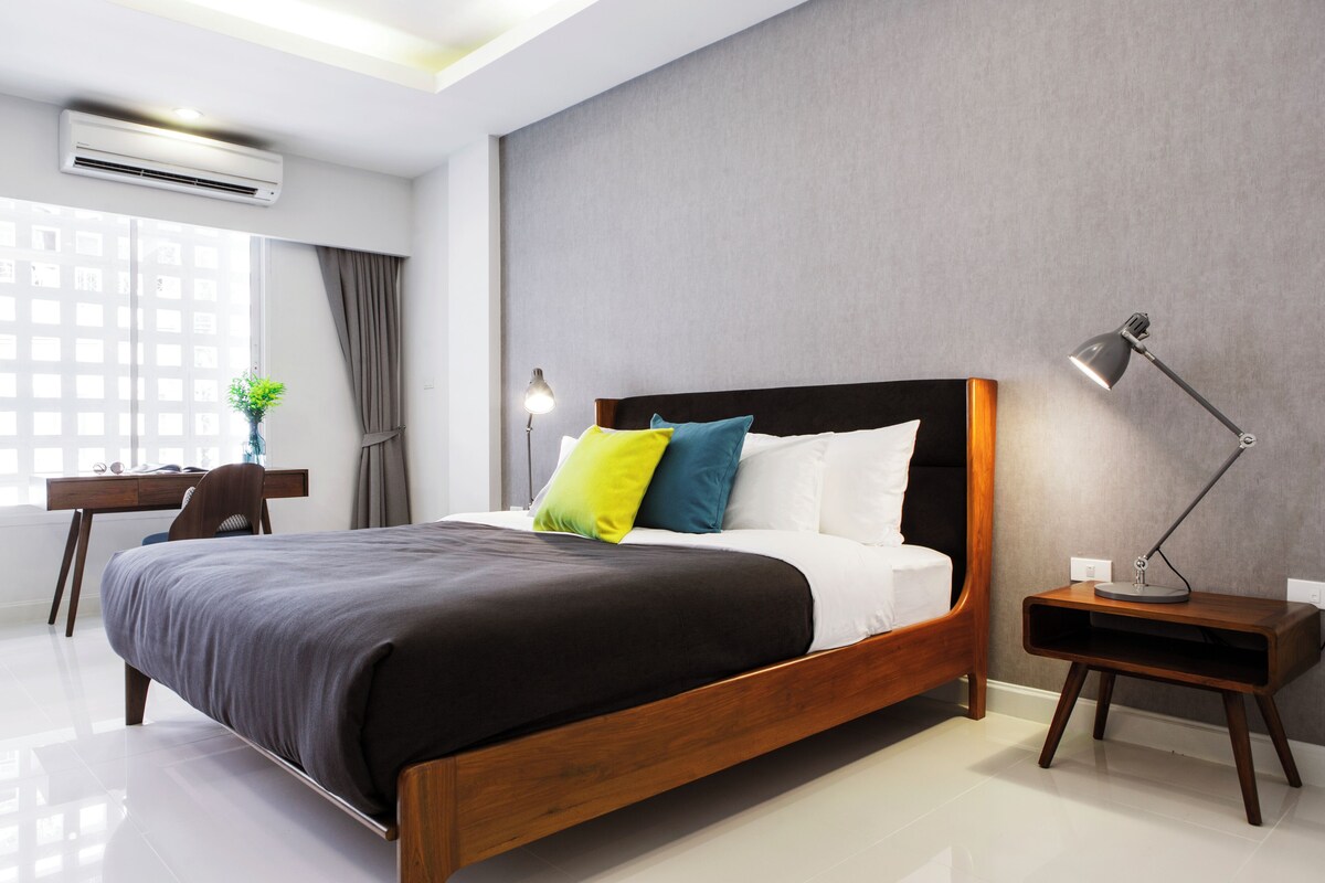 Ein modernes Schlafzimmer mit einem Holzbett, einem Schreibtisch und einem Stuhl.