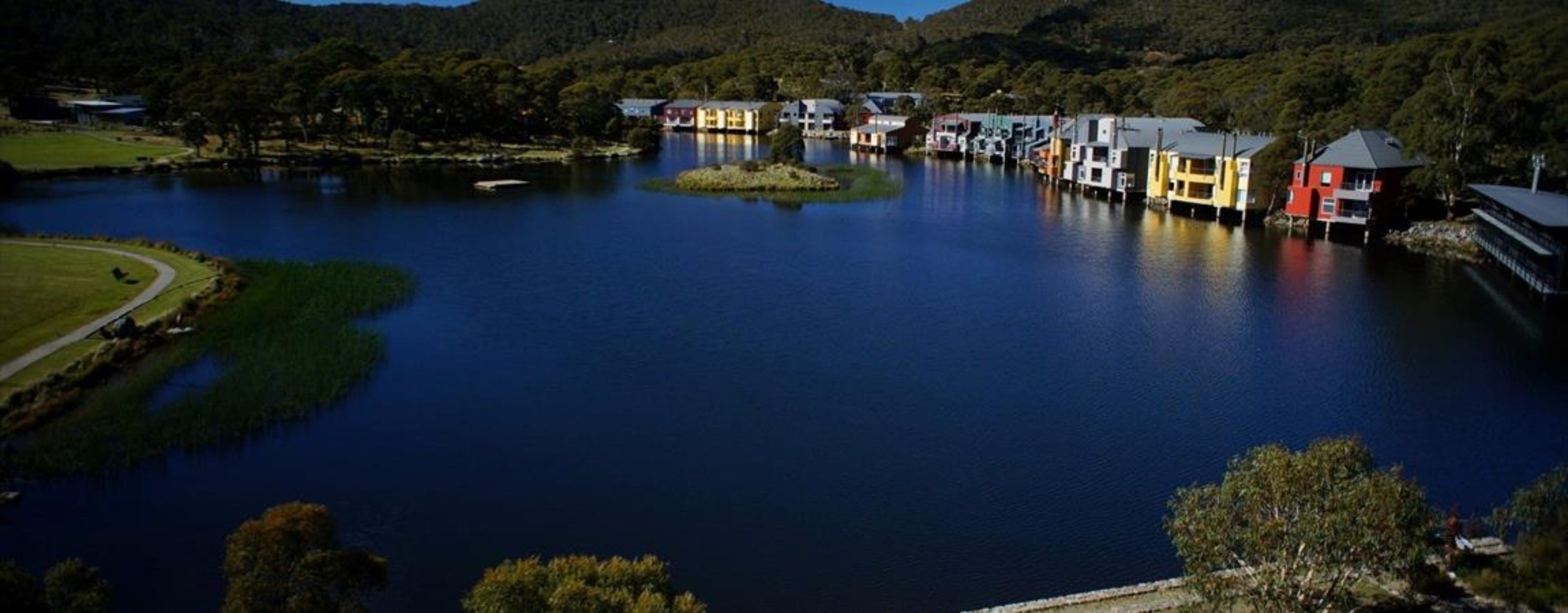 A lakeside property with multiple buildings, a dock, and a small island.
