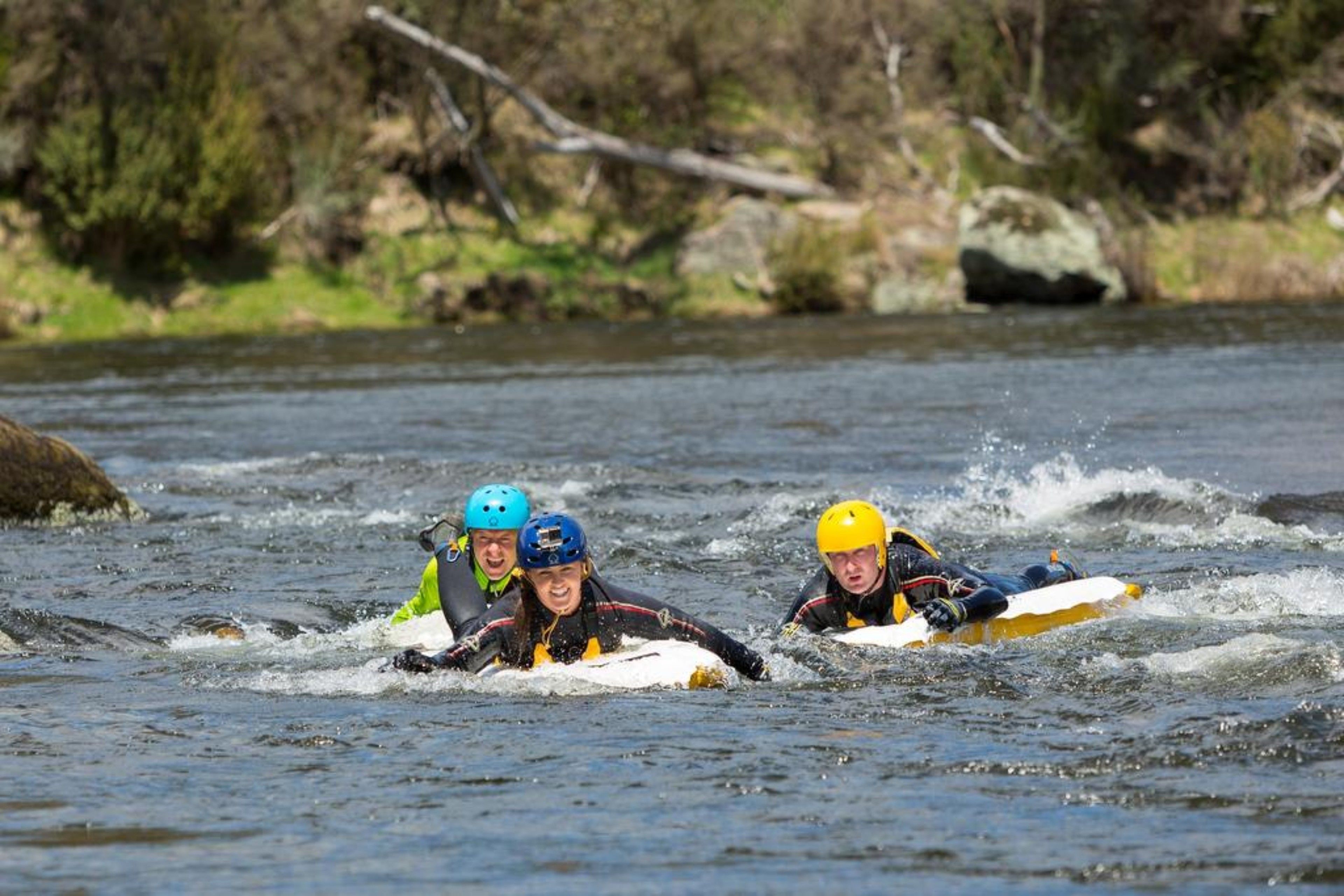 Tres personas en una balsa en un río.