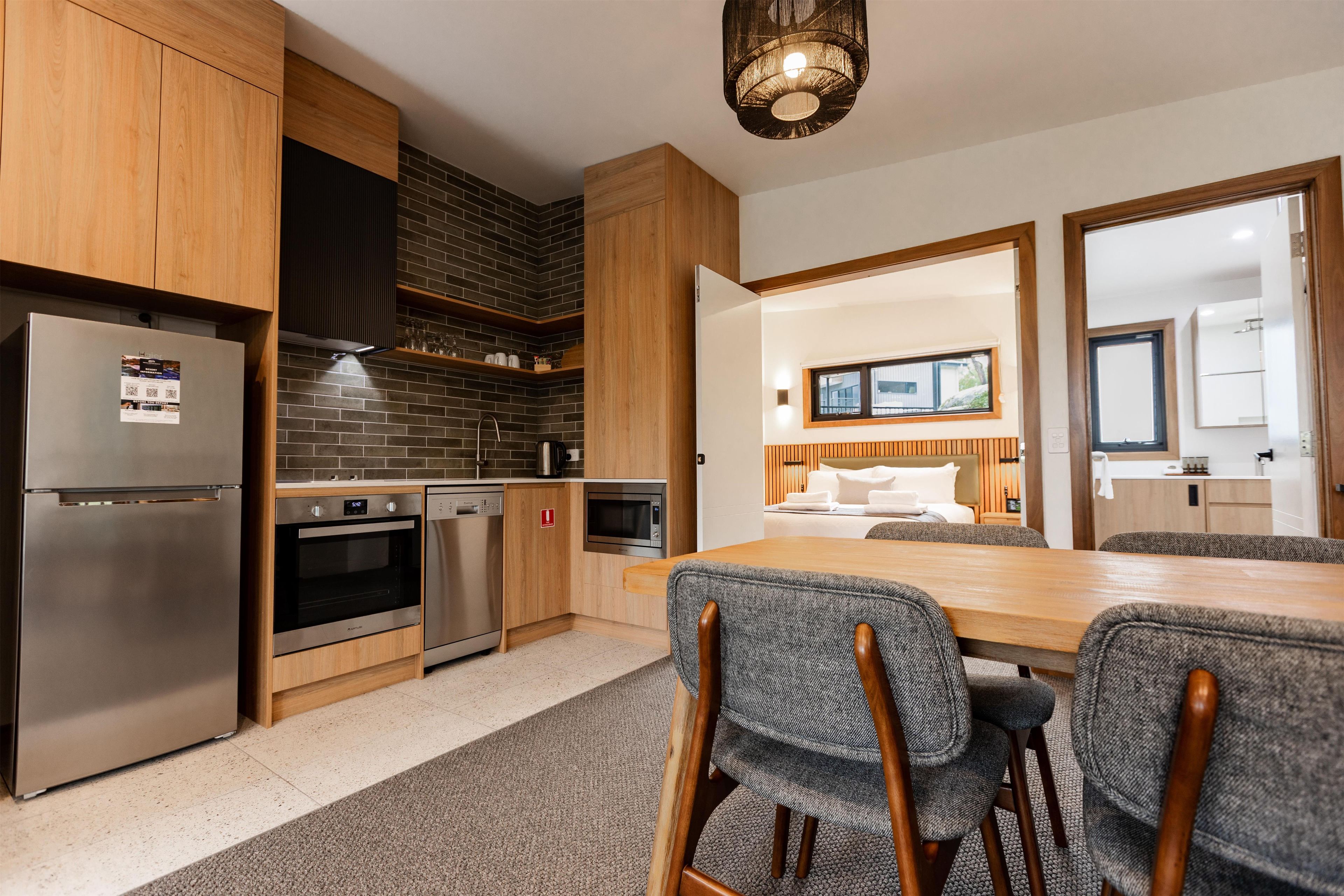Eine moderne Küche mit Edelstahlgeräten, einer Ziegelrückwand und Holzschränken.