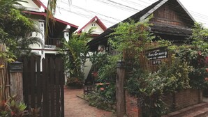 Un edificio de madera tradicional con un letrero que indica que es una casa de huéspedes o una posada.