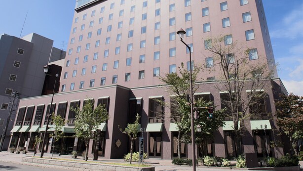 Un hôtel à plusieurs étages, doté d’une façade uniforme, de nombreuses fenêtres et d’un toit plat.