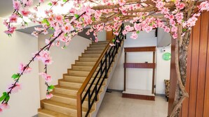 A staircase with a wooden handrail and a wall-mounted clock. - Admire Thonburi (Bangkok)