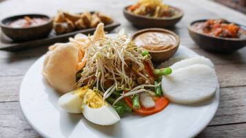Un plato de comida con diversos platos, incluyendo un sándwich, huevos cocidos y verduras.