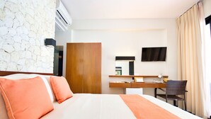 A hotel room with a bed, a desk, a mirror, and a TV. - Watercolors Boracay Dive Resort (Boracay Island)