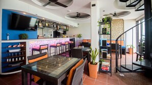 A modern restaurant with a bar area, dining tables, and a staircase. - Watercolors Boracay Dive Resort (Boracay Island)
