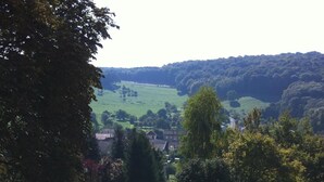 A cobblestone pathway leading to a scenic overlook with a view of a village and rolling hills in the distance. - FASTHOTEL LE RALE DES GENETS - Un hôtel FH COLLECTION  (Dun-sur-Meuse)