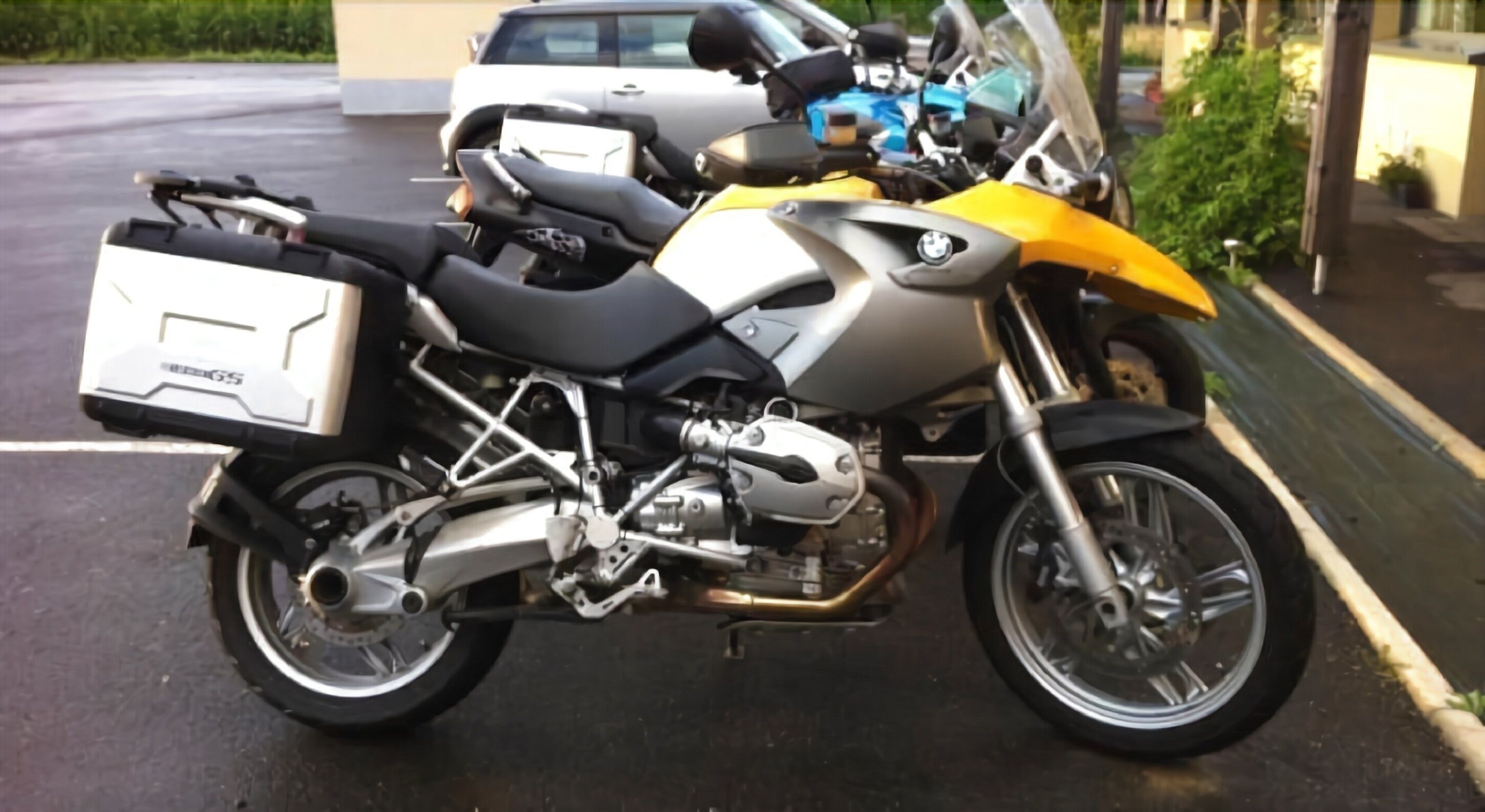 Une moto garée, avec un coffre de rangement à l’arrière.