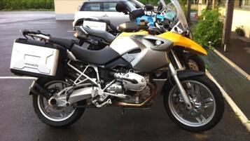 Une moto garée, avec un coffre de rangement à l’arrière.