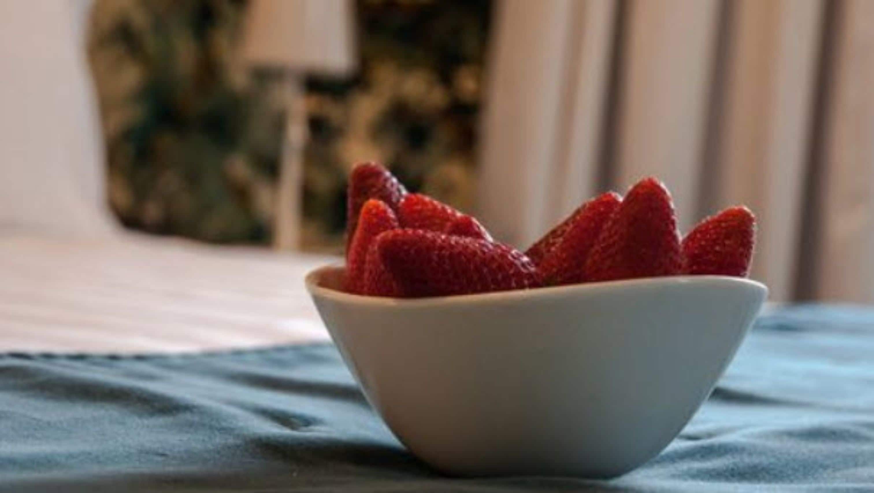 A bowl of strawberries on a table.