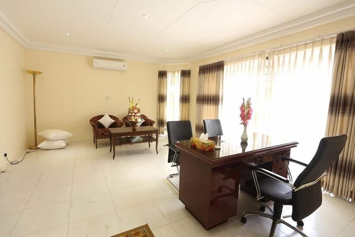 A well-lit office with a desk, chairs, and a dining area.