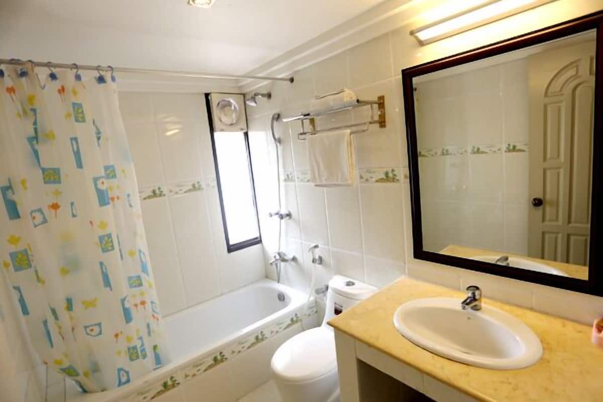 A bathroom with a bathtub, toilet, and sink.