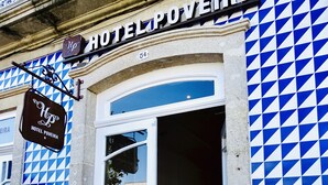 A hotel entrance with a blue and white checkered facade, a white door, and a sign reading "HOTEL POVEIRA." - Hotel Poveira (Porto)