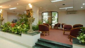 A lobby with a reception desk, seating area, and a staircase leading to an upper floor. - Rose wood Residence (Dhaka)