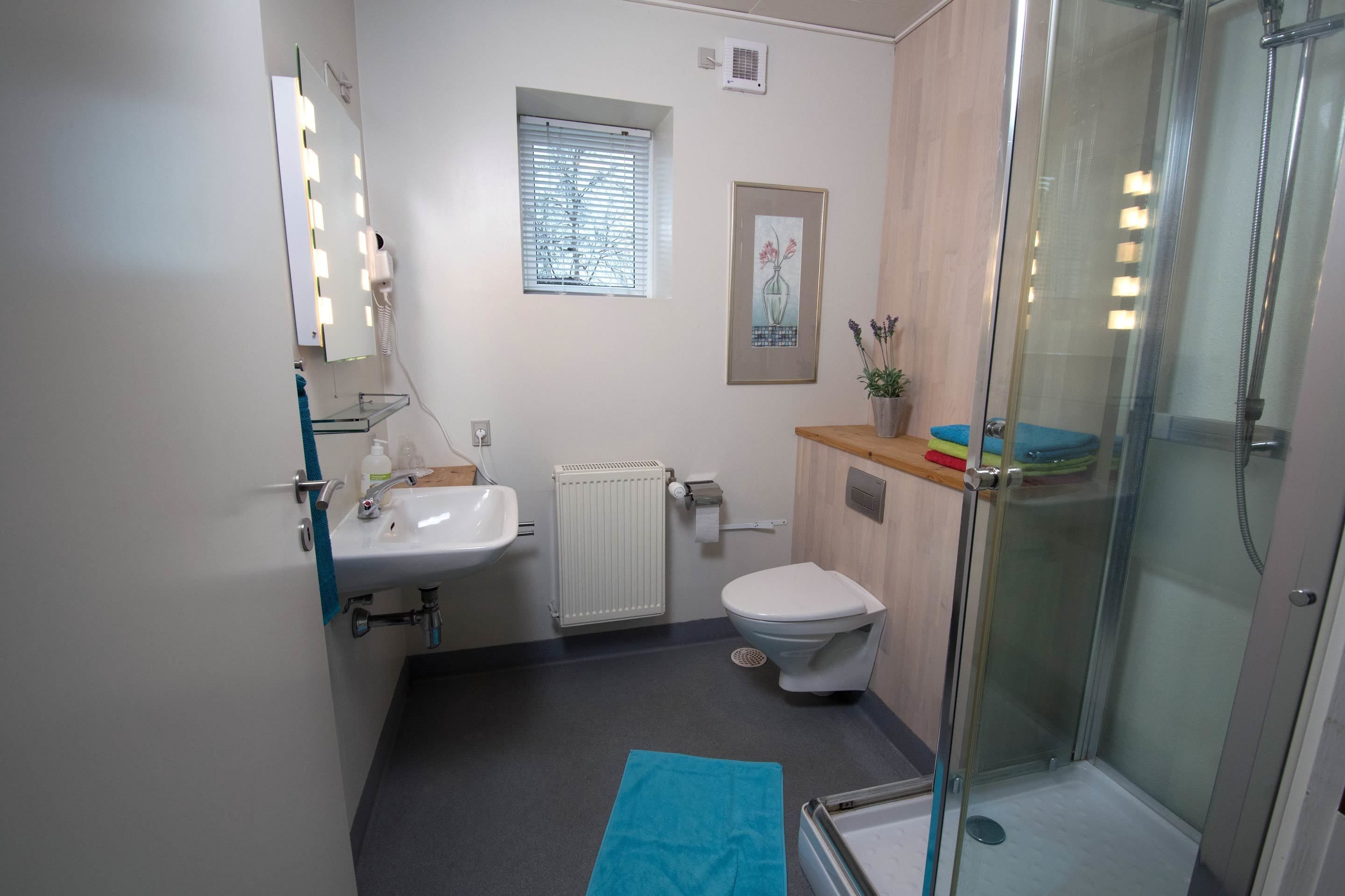 A bathroom with a sink, toilet, and glass-enclosed shower.