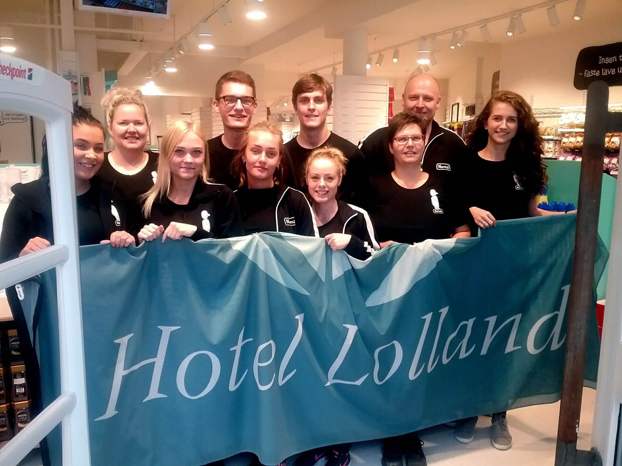 A group of people holding a banner with "Hotel Lollanda" written on it.