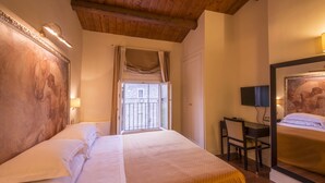 A hotel room with a large bed, a desk, a chair, and a television. - Albergo Sant'Emidio (Ascoli Piceno)