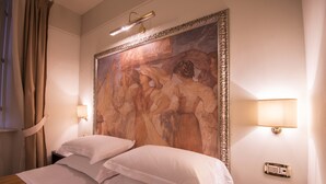 A hotel room with a large painting on the wall, two bedside lamps, and a bed with white linens. - Albergo Sant'Emidio (Ascoli Piceno)