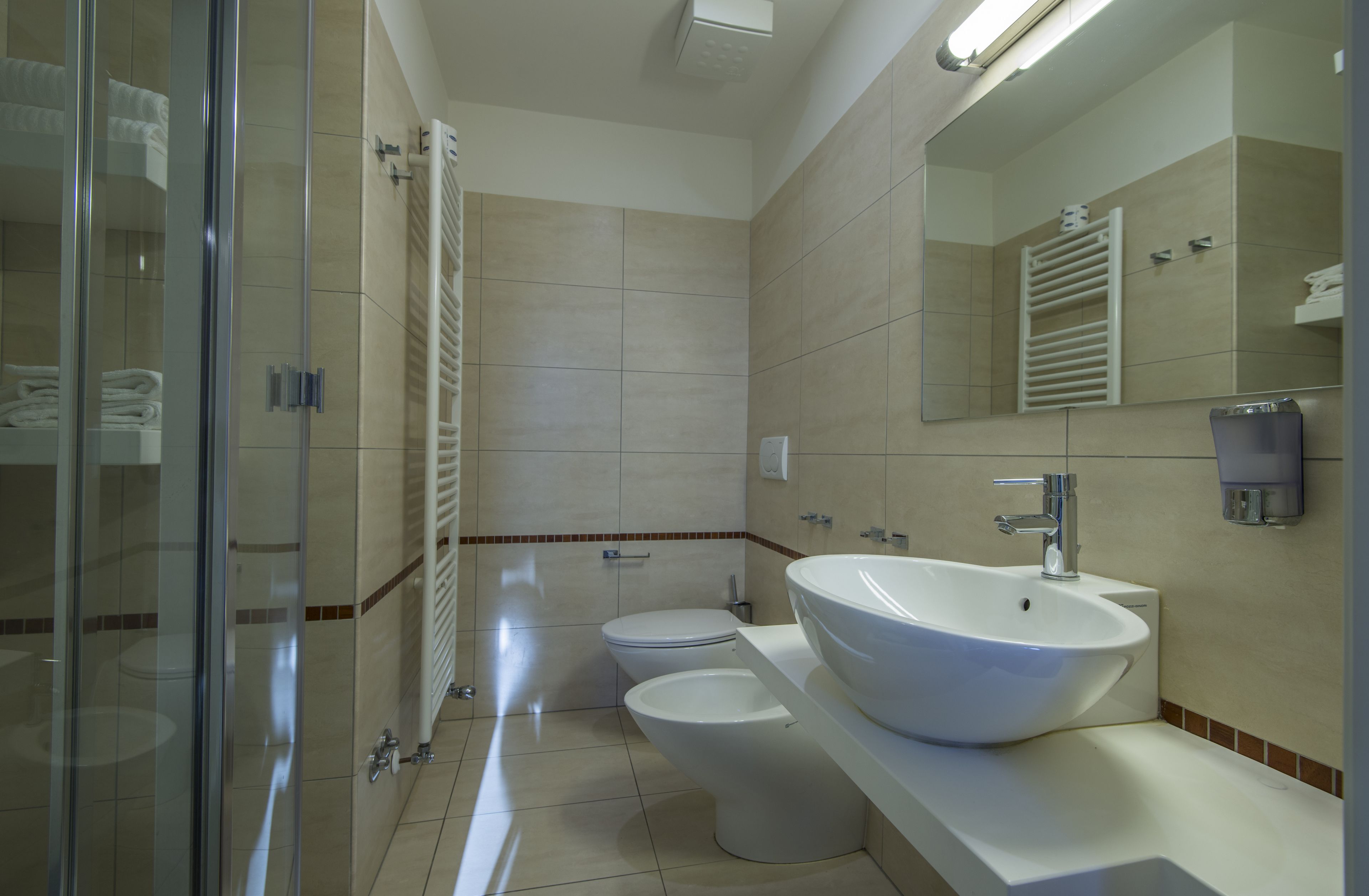 A modern bathroom with a glass shower enclosure, a white sink, and a toilet.