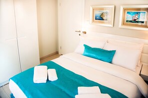 A hotel room with a bed, two framed pictures on the wall, and two towels on the bed. - Premium Residence Taksim Square (Istanbul)