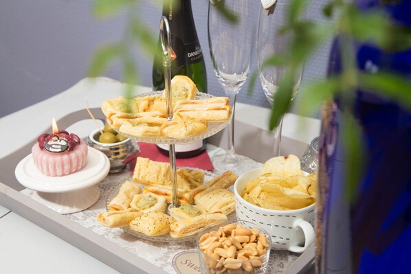 A tray with various pastries, a small cake, and a bottle of champagne.