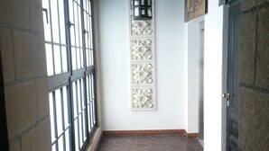 A corridor with a tiled floor, a black door, and a wall-mounted decorative panel. - Citadella Residence Appartments Vienna (Vienna)