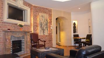 Suite exclusiva, 1 cama King size, para fumadores | Sala de estar | Televisión de pantalla plana y chimenea