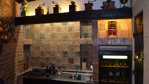 A kitchen with a brick backsplash, a built-in wine cooler, and various kitchen appliances. - Citadella Residence Appartments Vienna (Vienna)