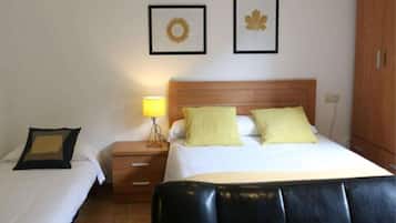 Een hotelkamer met een bed, nachtkastjes, een lamp en twee ingelijste foto’s aan de muur.