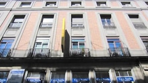 A multi-story building with a symmetrical facade, featuring evenly spaced windows and balconies.