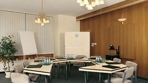 A conference room with a whiteboard, a refrigerator, and a plant. - Gasthaus Kupfer (Südharz)