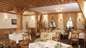 A restaurant with wooden beams, white tablecloths, and candle-lit tables. - Gasthaus Kupfer (Südharz)