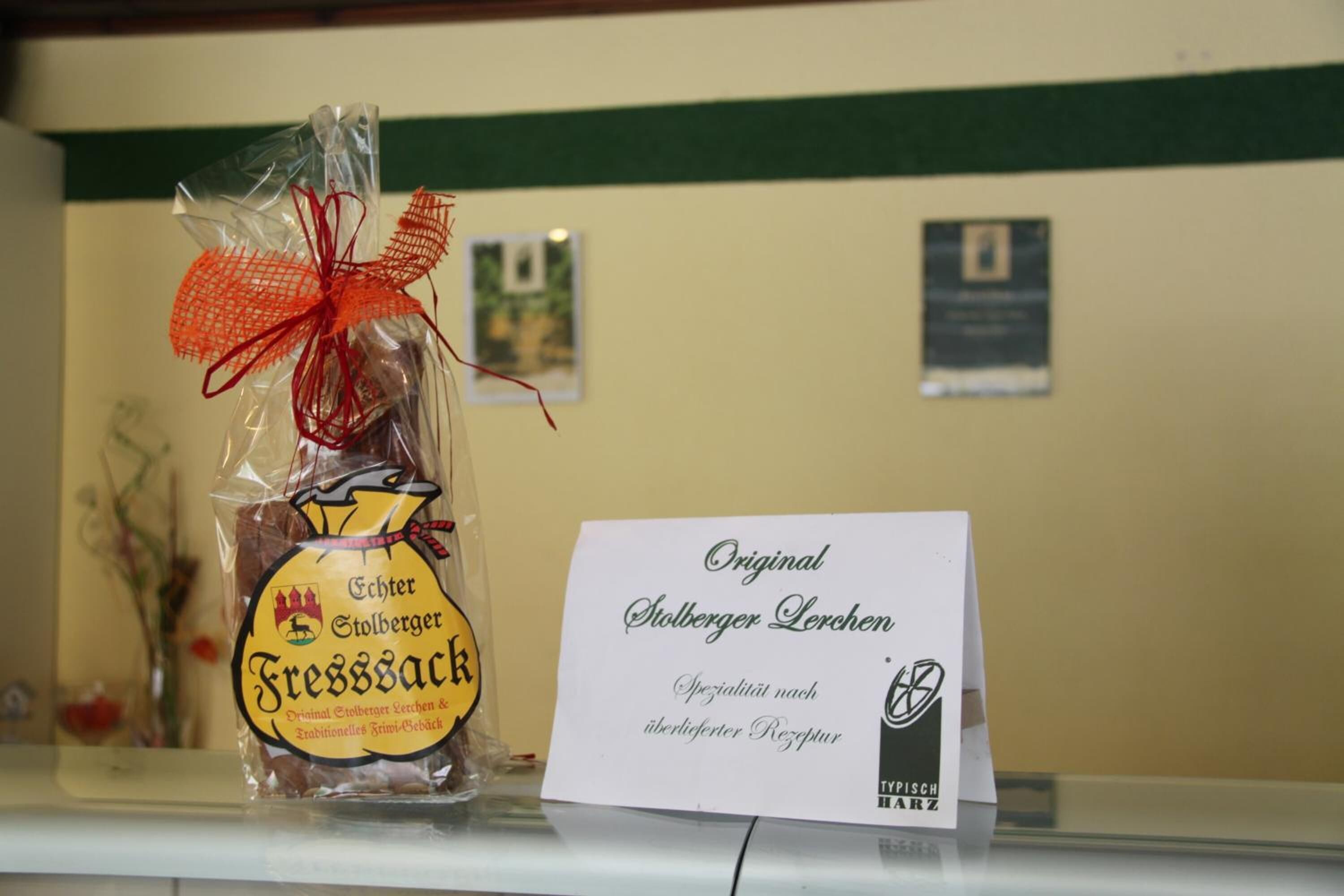 Un alimento envasado con la etiqueta 'Original Stolberger Linsen' sobre una encimera con un cartel.