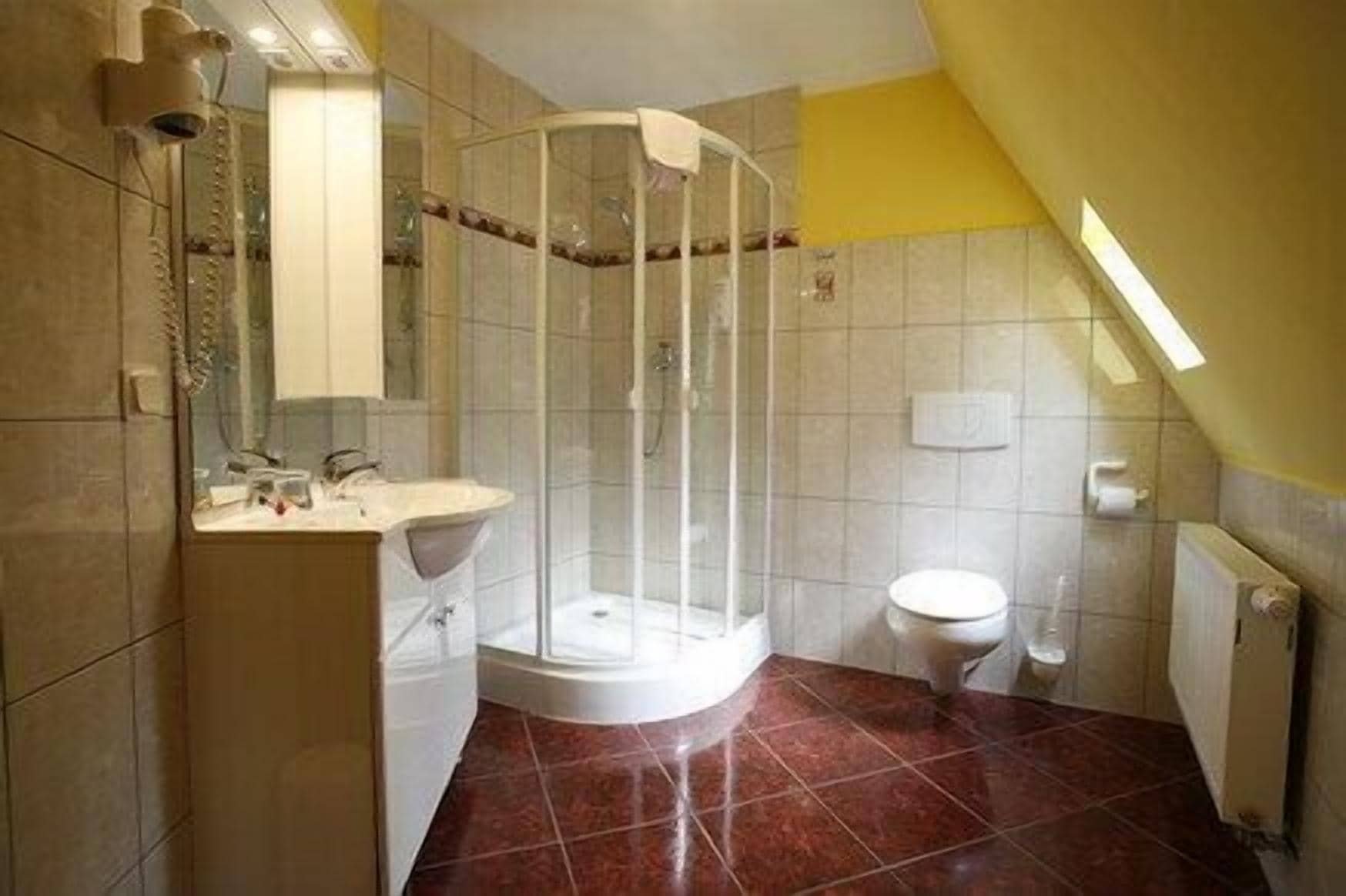 Ein Badezimmer mit Duschkabine, Toilette und Waschbecken.