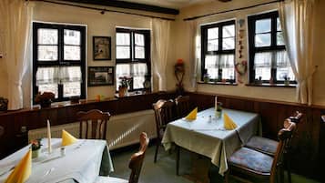 A cozy dining area with wooden furniture and large windows.