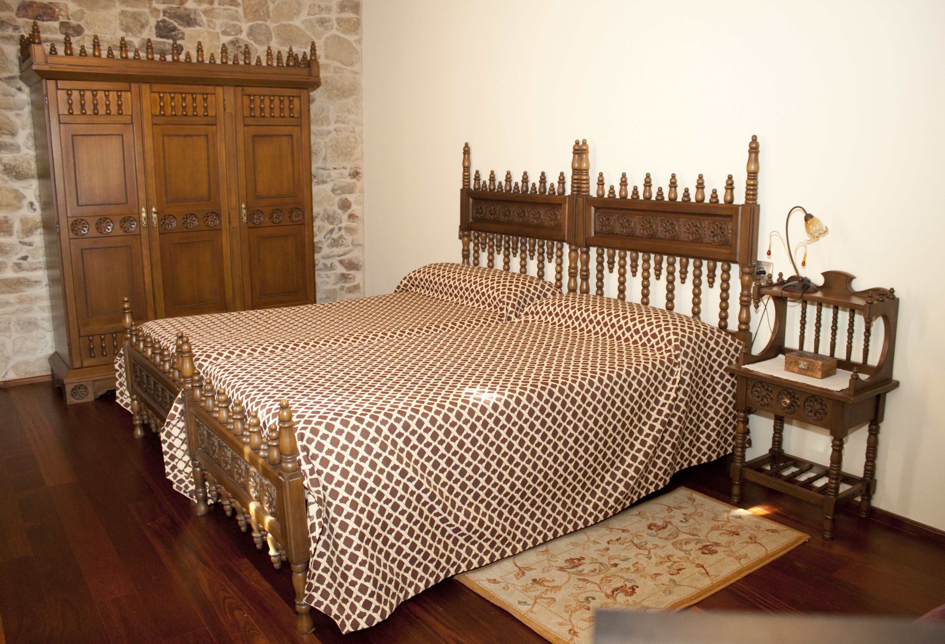 Ein Schlafzimmer mit einem hölzernen Bett, einem Nachttisch und einem Kleiderschrank.