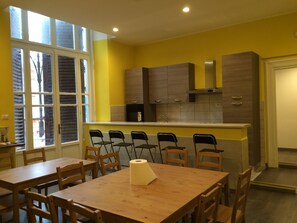 Una cocina moderna con paredes amarillas, armarios de madera y un ventanal amplio.