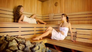 Una sauna con bancos de madera y suelo de piedra.