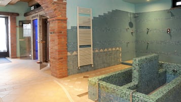 Relax in a spacious bathroom with a large bathtub, shower area, and brick archway.