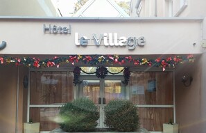 A hotel entrance with a sign reading "le Village". - Hôtel Le Village (Gif-sur-Yvette)