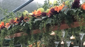 A table set for a meal with a variety of flowers and a cake. - Pousada Les Roches (Petrópolis)