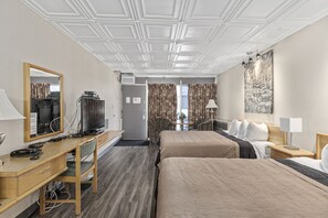 A hotel room with two beds, a desk with a computer, a TV, and a large window with curtains. - Catalina Motel (Sault Ste. Marie)