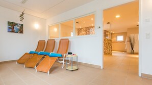 A room with three sun loungers, a small table with a fruit bowl, and a painting on the wall. - Ferienpark Plauer See (Alt Schwerin)