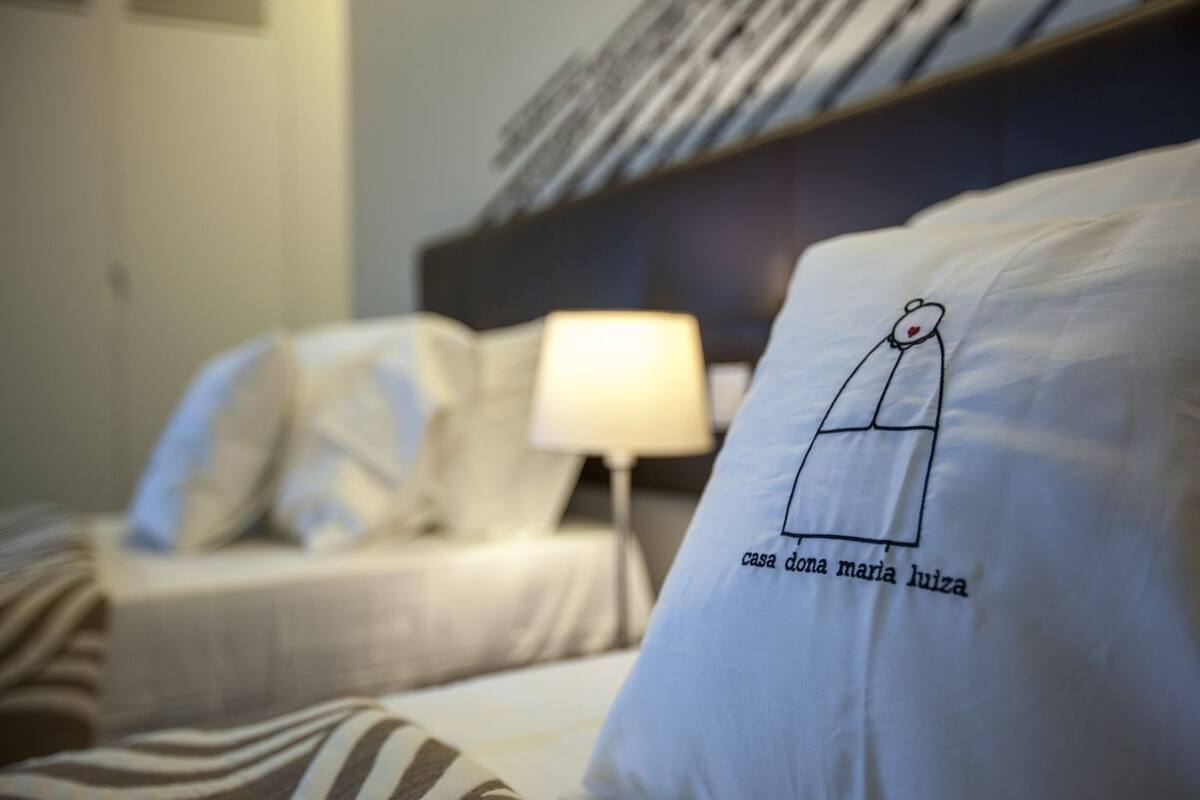 Ein Hotelzimmer mit Bett, Nachttisch und Lampe.