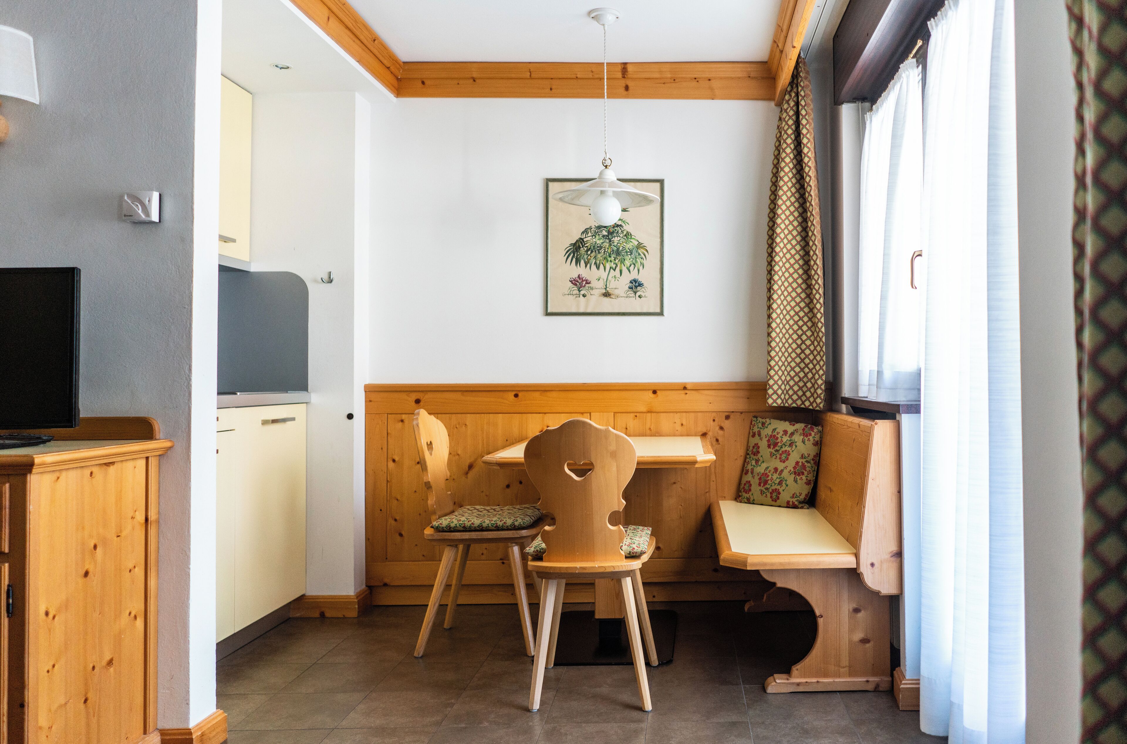 A cozy room with a wooden bench, a table, and a television.