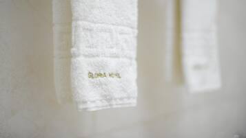 A white towel hanging on a wall with the text "GLORIA HOTEL" visible.