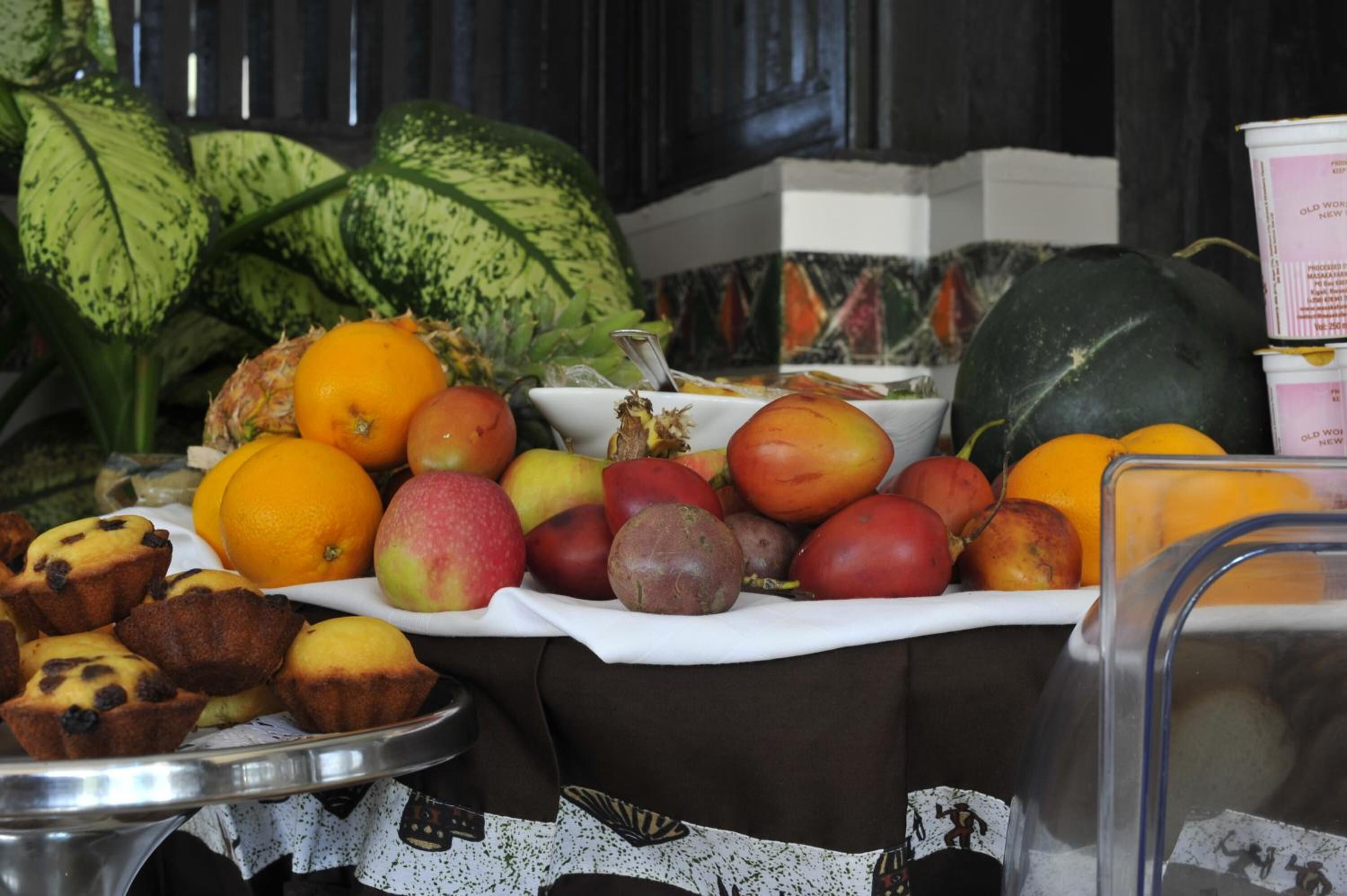 A buffet table with various fruits and muffins.