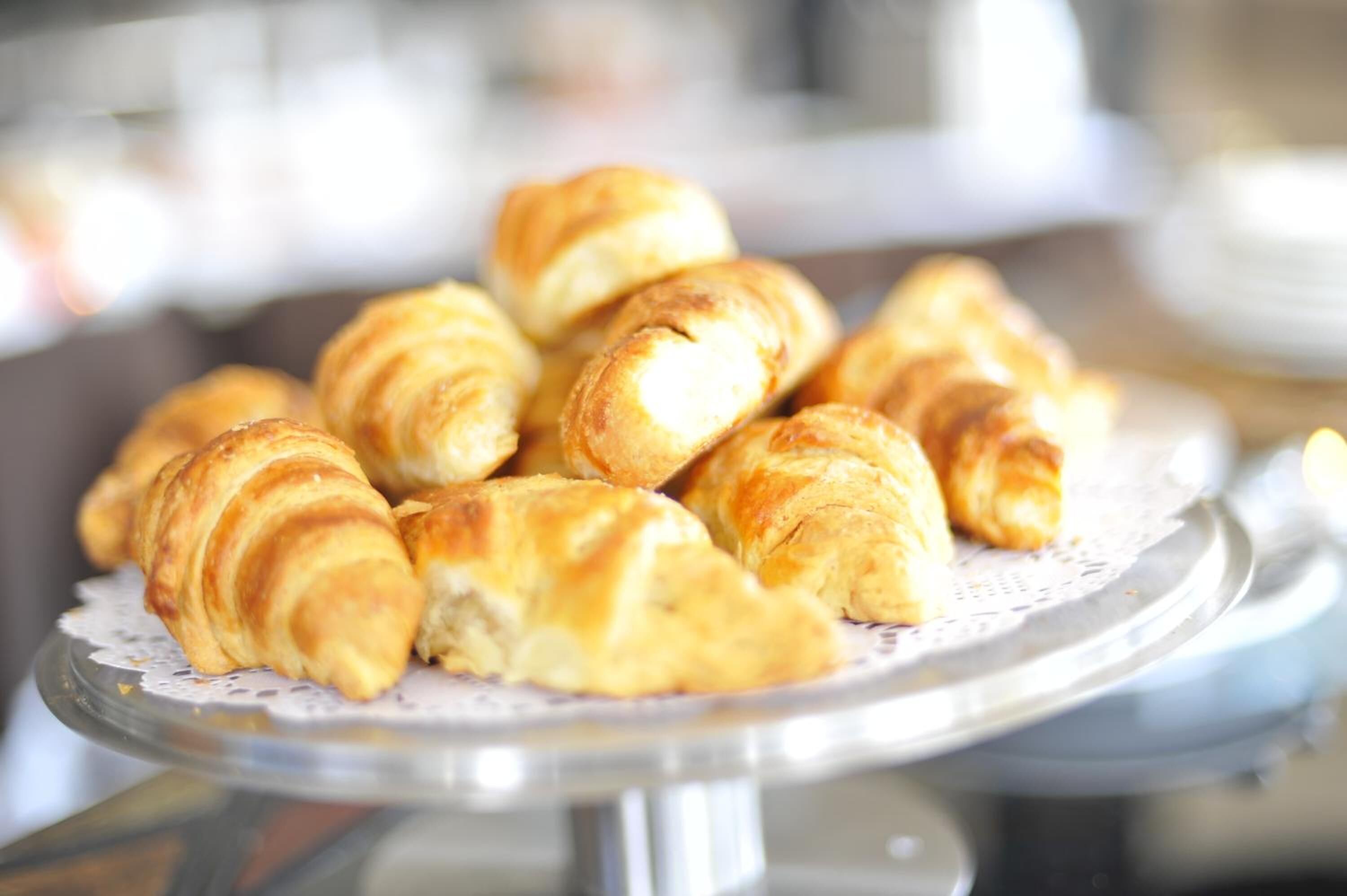 En tallrik med croissanter på ett genomskinligt glasfat.