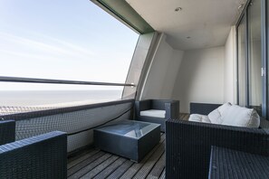 Enjoy the breathtaking sea views from this balcony with a sofa and table.