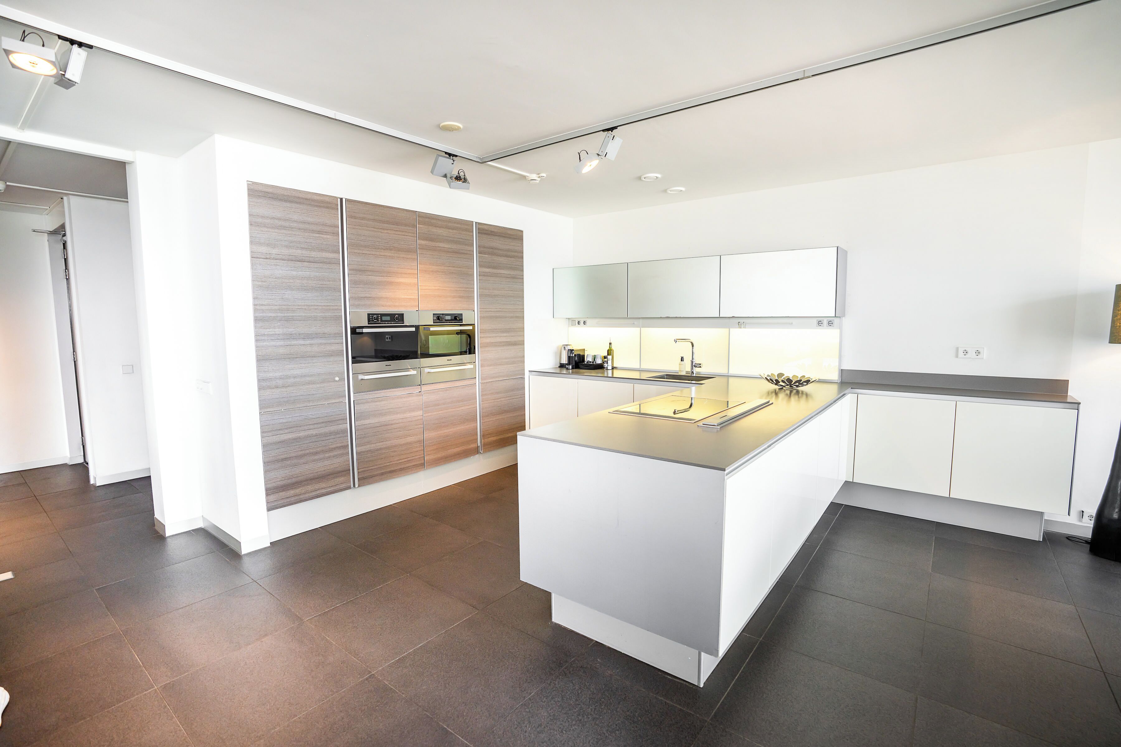 A modern kitchen with a central island, built-in appliances, and a sleek design.